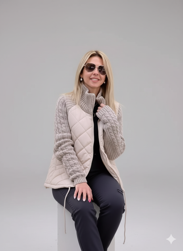 Woman modeling quilted beige puffer vest with gray knitted sweater sleeves. Ideal for winter online store.