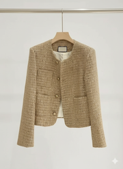VYRO Elegant Tweed Cropped Jacket in champagne color, featuring gold buttons and a classic round neckline, displayed on a hanger against a minimalist background.